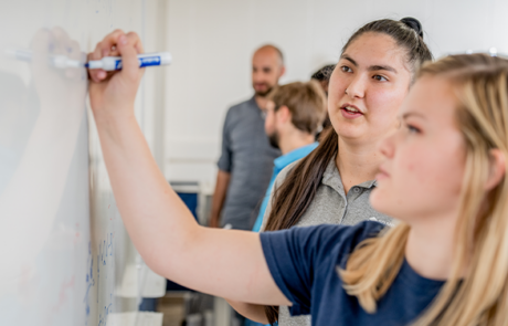 girl writing on a white board